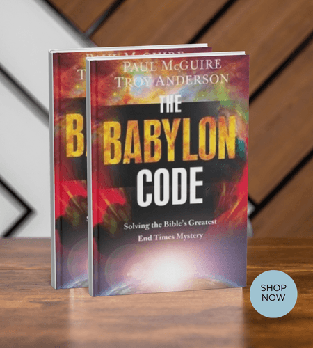 Two copies of "The Babylon Code" book by Paul McGuire on a wooden table.