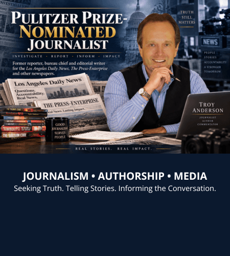 Journalist Troy Anderson at a desk with newspapers and books, highlighting his Pulitzer Prize nomination.